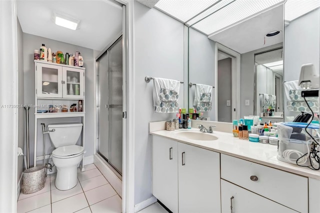 bathroom featuring tile patterned flooring, vanity, an enclosed shower, and toilet