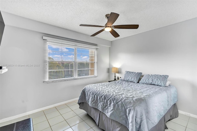 bedroom featuring light tile patterned flooring, ceiling fan, and a textured ceiling