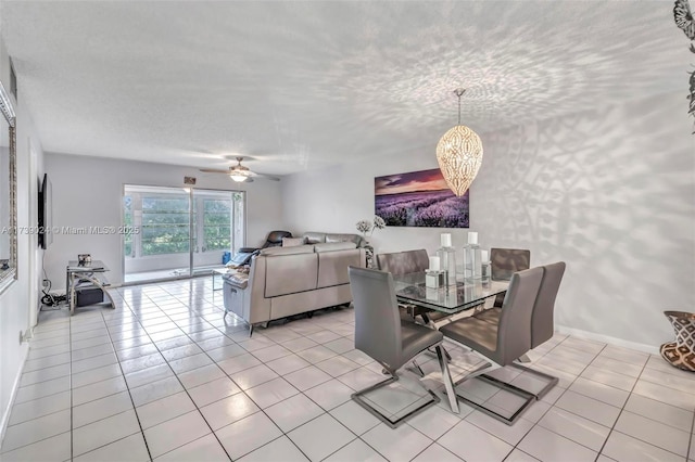 dining area featuring ceiling fan with notable chandelier, a textured ceiling, and light tile patterned floors