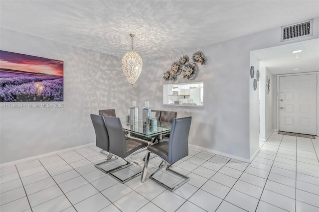 dining room with a textured ceiling and light tile patterned flooring