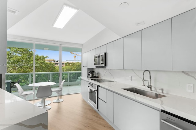 2127 Brickell Ave Unit 705, Miami, FL 33129 - kitchen with appliances with stainless steel finishes, expansive windows, modern cabinets, tasteful backsplash, and light stone counters