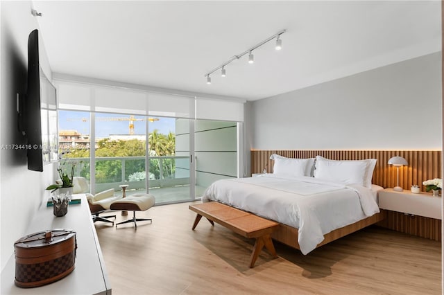2127 Brickell Ave Unit 705, Miami, FL 33129 - bedroom with light wood-style flooring, track lighting, floor to ceiling windows, a wainscoted wall, and access to exterior