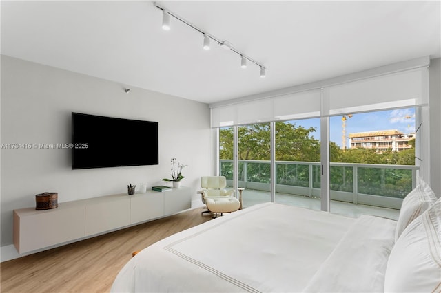 2127 Brickell Ave Unit 705, Miami, FL 33129 - bedroom featuring light wood-type flooring, rail lighting, and floor to ceiling windows