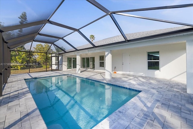 view of swimming pool with glass enclosure and a patio area