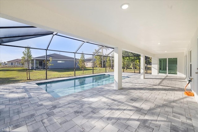 view of pool with a patio, a yard, and glass enclosure