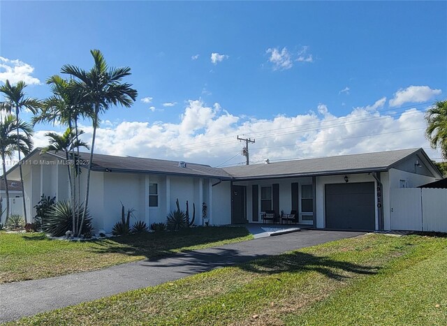 ranch-style house with a garage and a front lawn