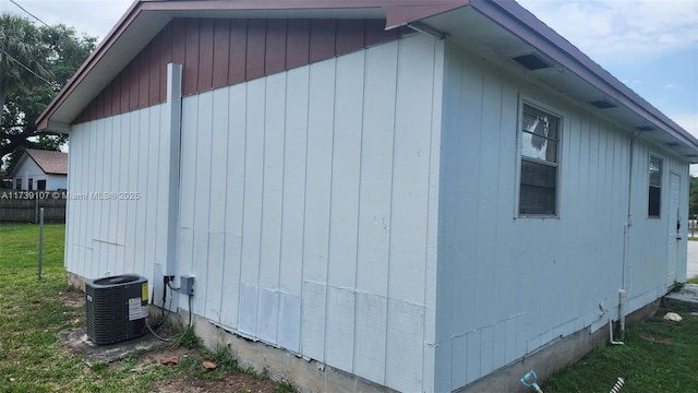 view of side of property with a yard and cooling unit