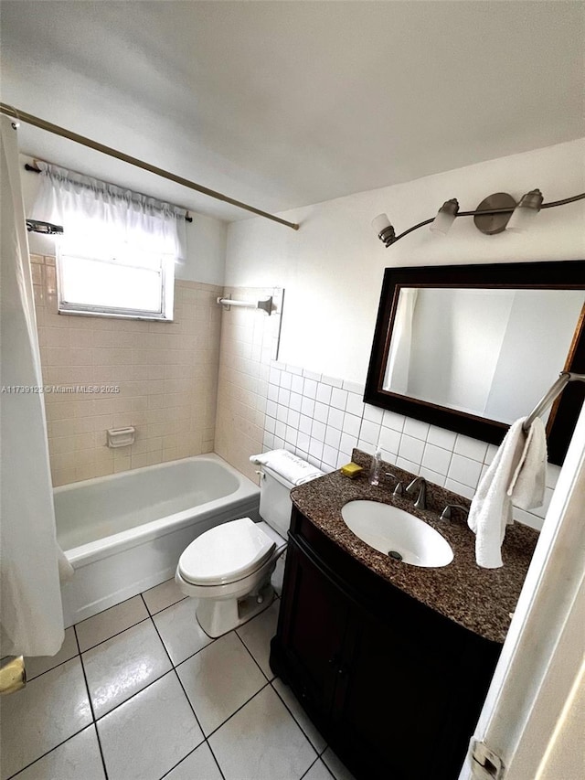 full bathroom with tile walls, tile patterned flooring, tiled shower / bath combo, vanity, and toilet