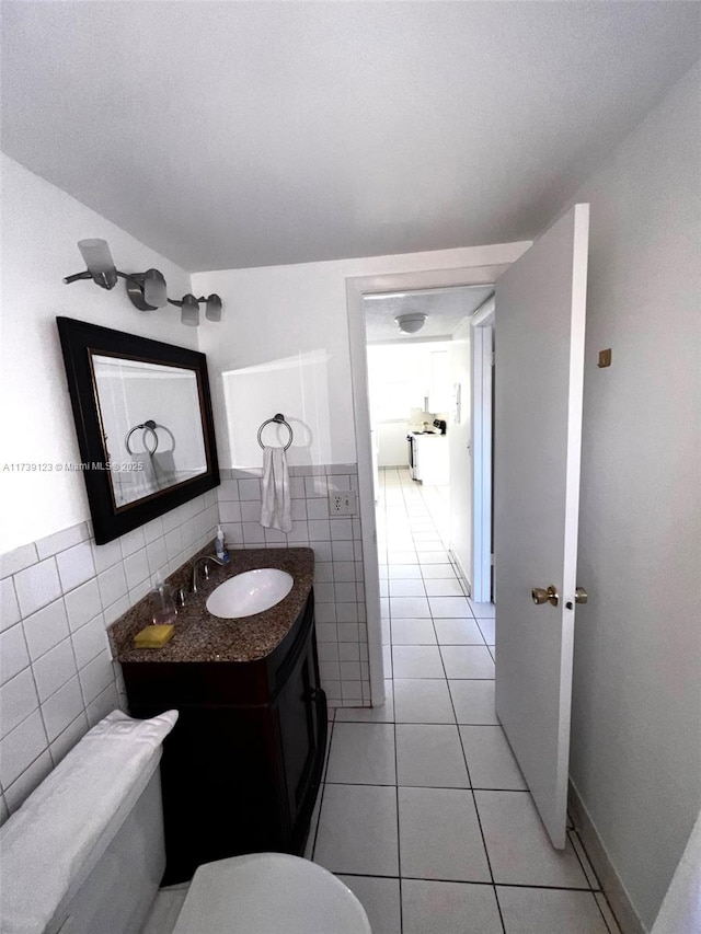 bathroom with vanity, tile patterned flooring, toilet, and tile walls