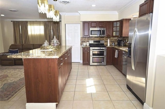 kitchen featuring pendant lighting, light tile patterned floors, crown molding, and appliances with stainless steel finishes