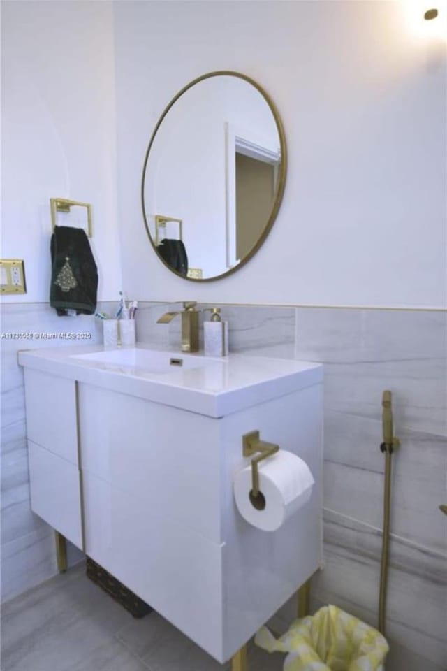 bathroom featuring vanity and tile walls