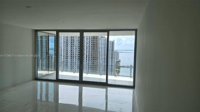 empty room featuring a wall of windows and a water view