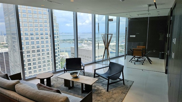 tiled living room with floor to ceiling windows and a water view