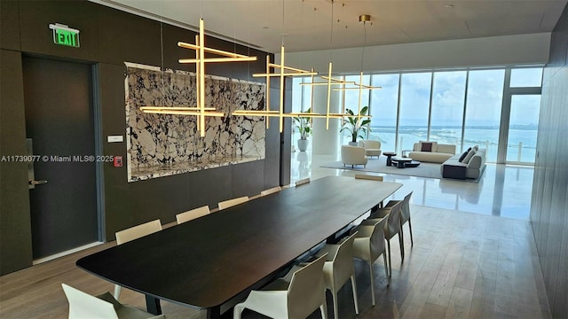 dining area featuring hardwood / wood-style flooring and a water view