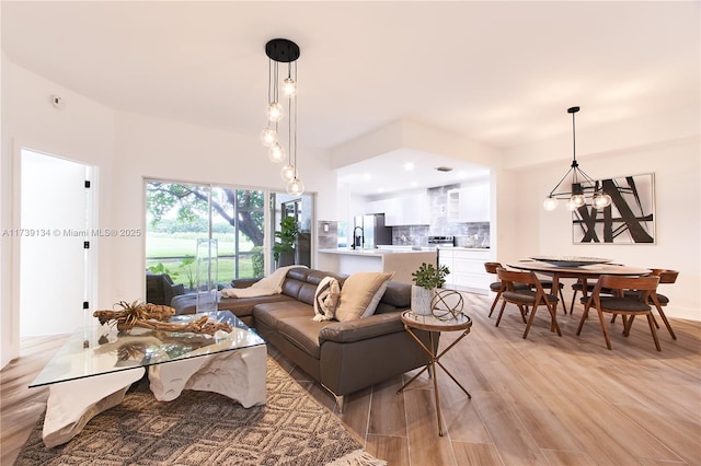 living room with sink, a chandelier, and light hardwood / wood-style floors