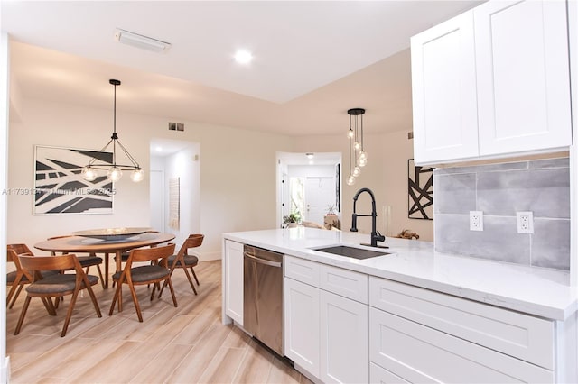 kitchen featuring sink, white cabinetry, light stone counters, dishwasher, and pendant lighting