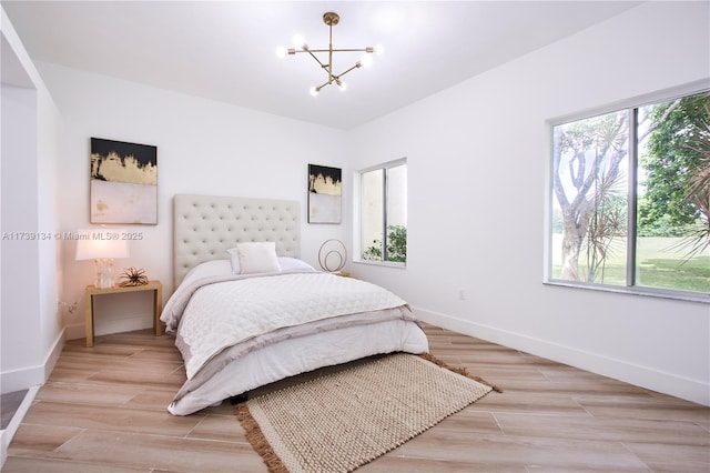 bedroom featuring an inviting chandelier and multiple windows