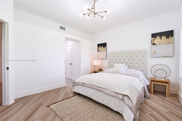 bedroom featuring light hardwood / wood-style floors and a notable chandelier