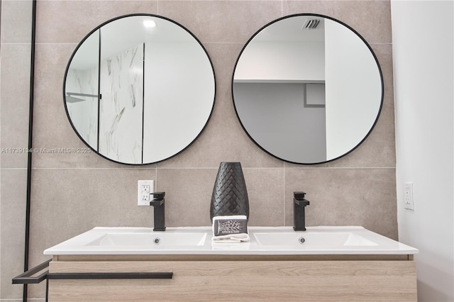 bathroom with vanity and tile walls