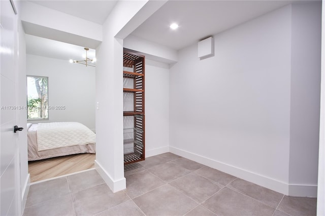 unfurnished bedroom with light tile patterned flooring and a chandelier