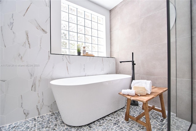 bathroom featuring a tub and tile walls