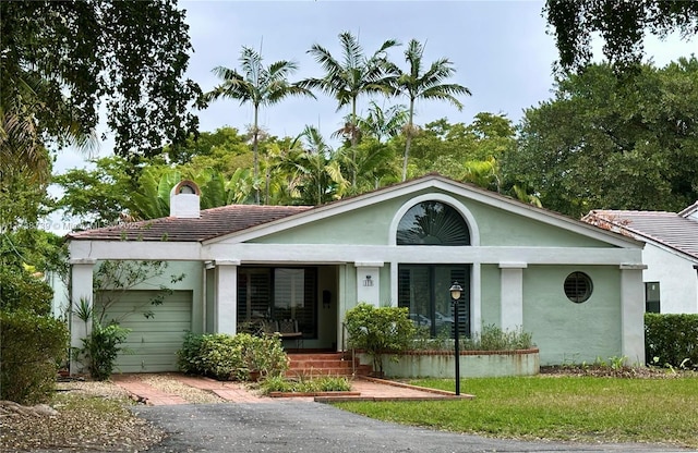 ranch-style home featuring a garage and a front lawn