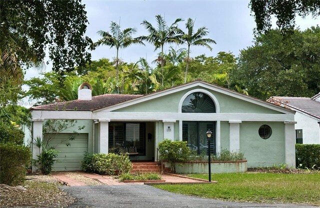 ranch-style house with a garage and a front yard