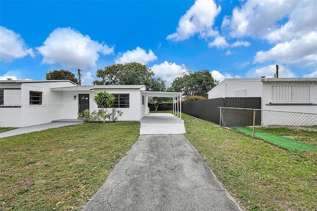 view of front of house with a front lawn and a carport