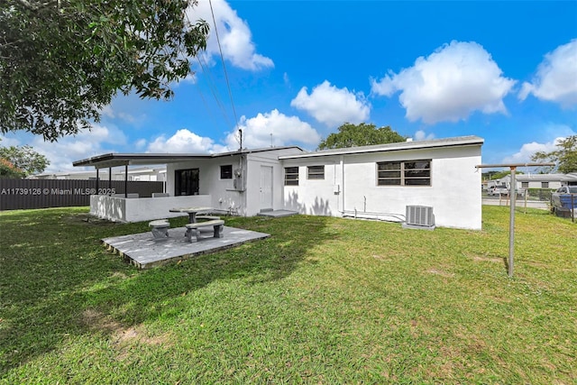 back of house with a patio area, a lawn, and central air condition unit