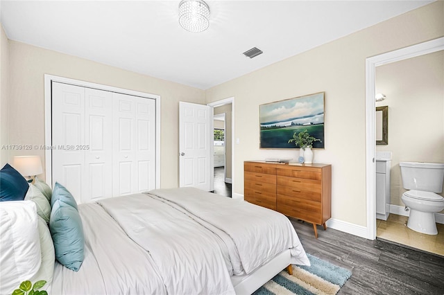 bedroom with ensuite bathroom, dark wood-type flooring, and a closet