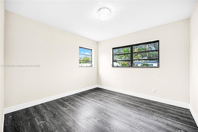 unfurnished room with dark hardwood / wood-style flooring