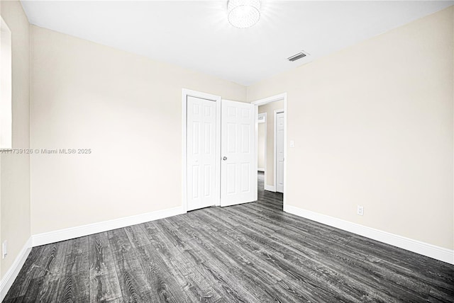 unfurnished room featuring dark wood-type flooring