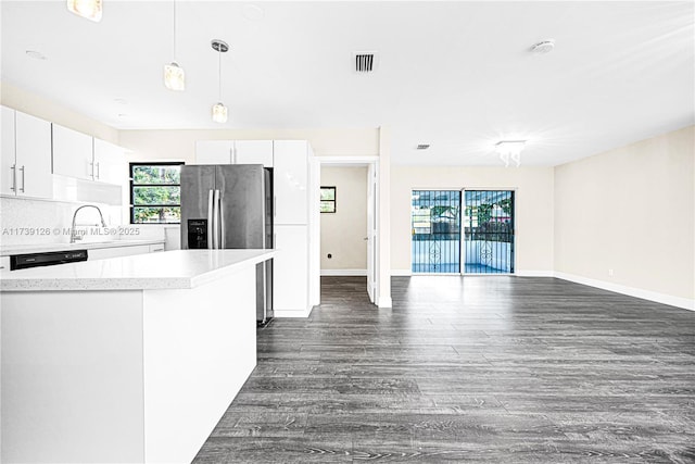 kitchen with pendant lighting, white cabinetry, black dishwasher, dark hardwood / wood-style flooring, and stainless steel fridge with ice dispenser