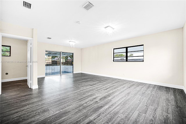 unfurnished room featuring a healthy amount of sunlight and dark wood-type flooring