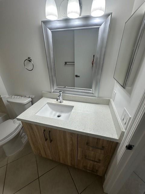 bathroom featuring tile patterned flooring, vanity, and toilet