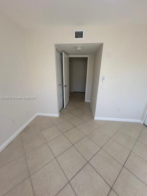 spare room featuring light tile patterned floors, baseboards, and visible vents