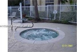 view of pool with a patio, fence, and a hot tub