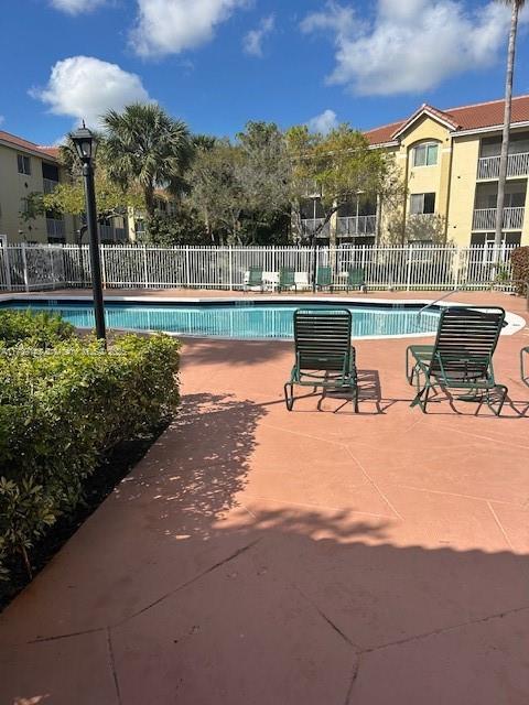 pool with a patio and fence