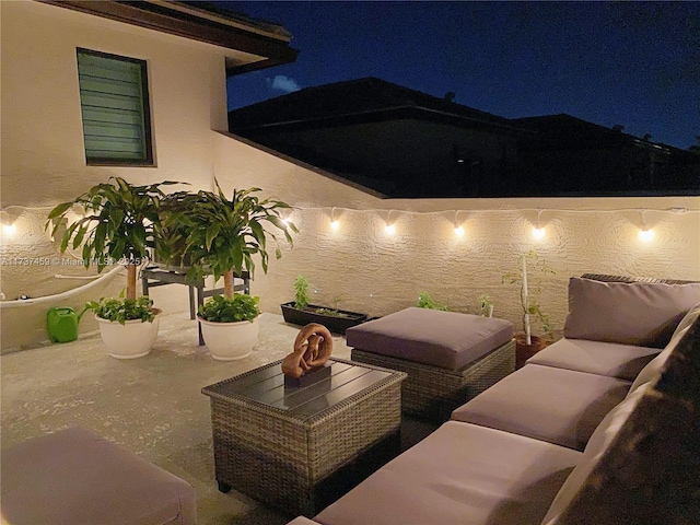 patio at night with a water view and outdoor lounge area