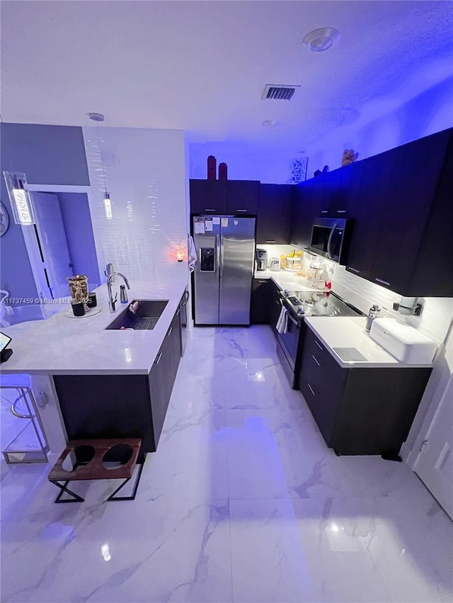 kitchen with appliances with stainless steel finishes, sink, and a breakfast bar