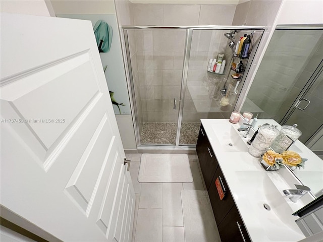 bathroom featuring vanity, a shower with door, and tile patterned flooring