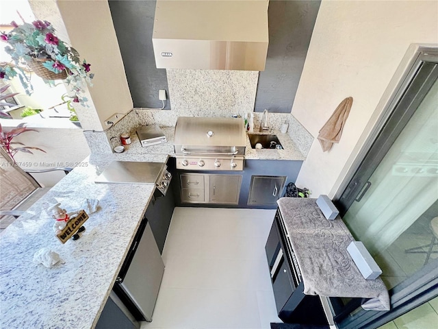 kitchen featuring light stone countertops, sink, and tile patterned floors