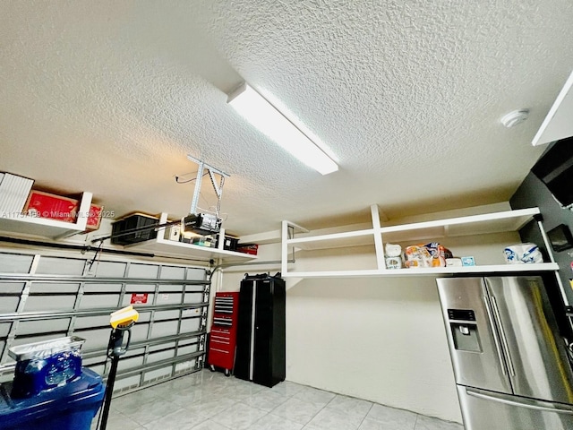 garage featuring stainless steel fridge with ice dispenser