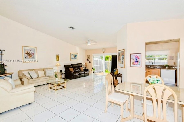 tiled living room featuring ceiling fan, sink, and vaulted ceiling