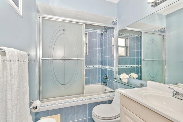 full bathroom with toilet, vanity, and shower / bath combination with glass door