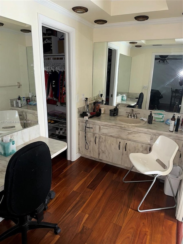 bathroom featuring crown molding, wood-type flooring, and vanity