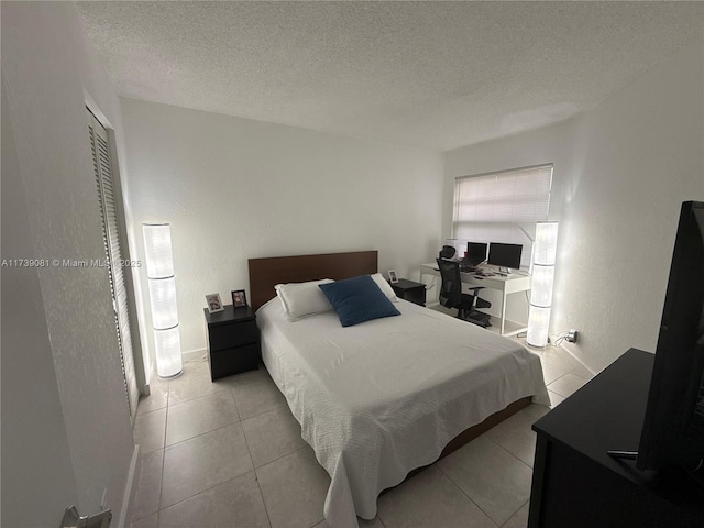 tiled bedroom featuring a textured ceiling