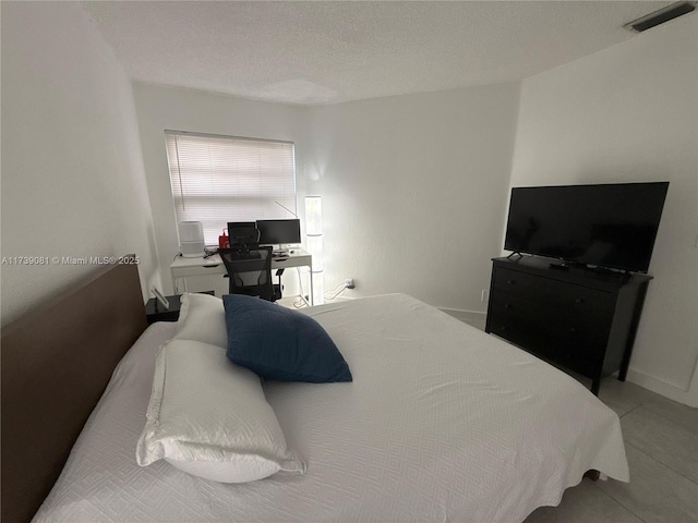 tiled bedroom featuring a textured ceiling