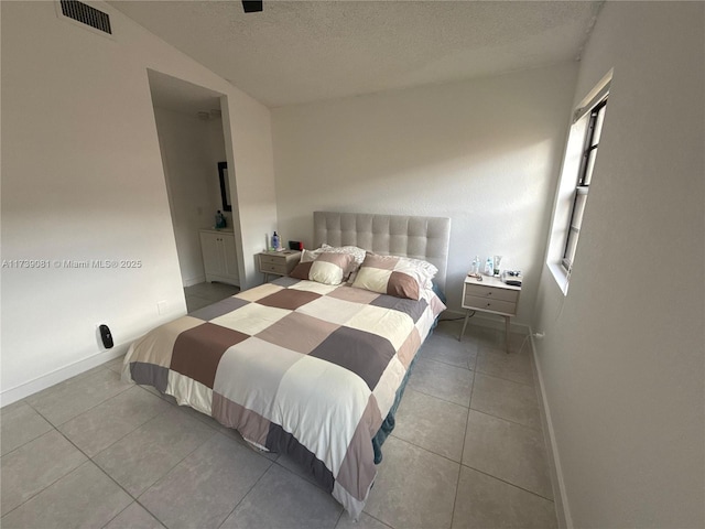 tiled bedroom featuring a textured ceiling