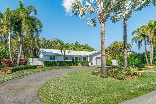 ranch-style home with a garage and a front lawn